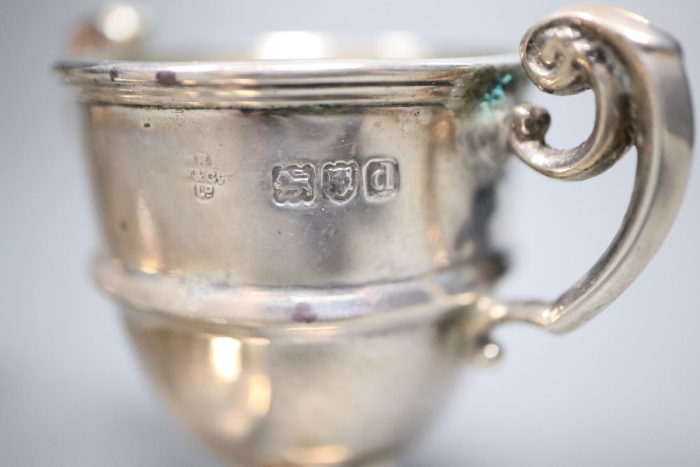 A cased pair of late Victorian small silver trophy shaped pepper pots, Horace Woodward & Co, London, 1899, 67mm,